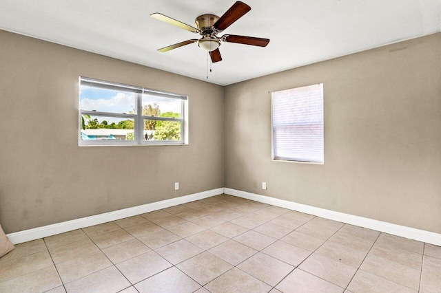 tiled spare room featuring ceiling fan