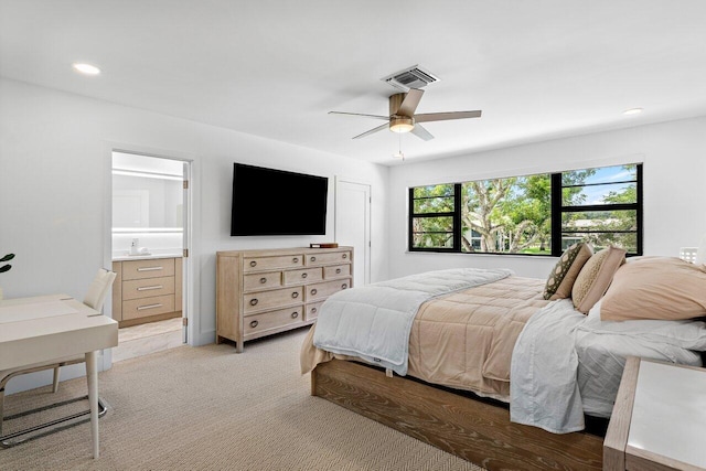 carpeted bedroom with ceiling fan and ensuite bathroom