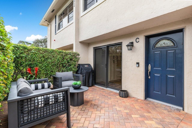 doorway to property with a patio area and outdoor lounge area