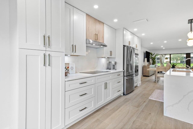 kitchen with white cabinets, stainless steel fridge, sink, and black electric stovetop