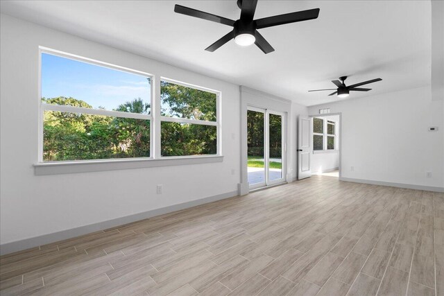 empty room featuring light hardwood / wood-style flooring, plenty of natural light, and ceiling fan