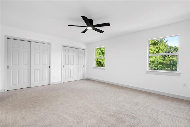 unfurnished bedroom with multiple windows, ceiling fan, and carpet floors