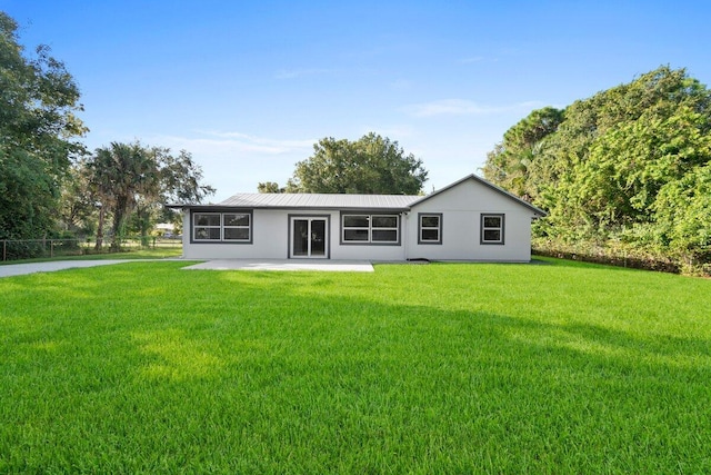 back of property with a patio area and a lawn