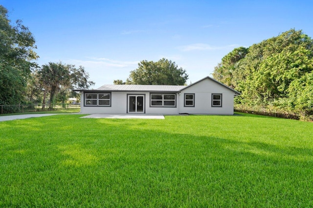810 Bradley St, Fort Pierce, FL 34982 - rear view of house featuring a patio, a yard, stucco siding, and metal roof