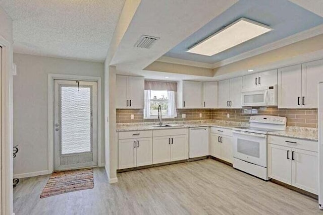 kitchen with white cabinetry, sink, white appliances, and light hardwood / wood-style flooring