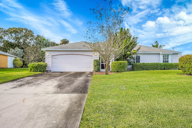 ranch-style house featuring a garage and a front lawn