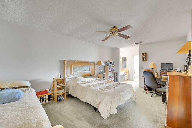 carpeted bedroom featuring ceiling fan, ensuite bathroom, and a textured ceiling