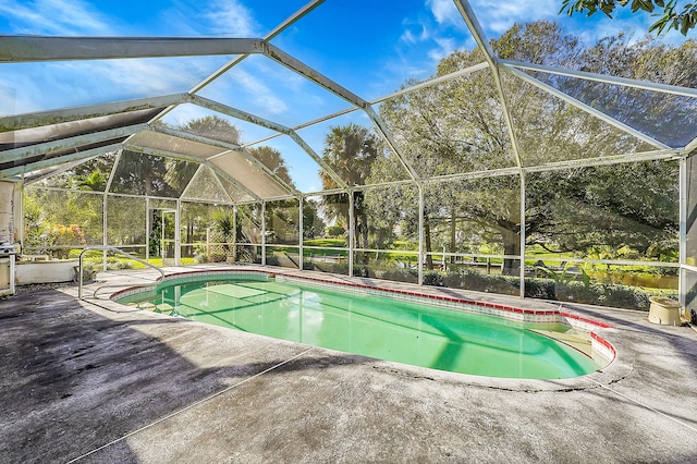 view of swimming pool with glass enclosure and a patio area