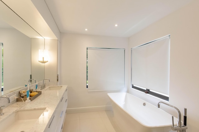 bathroom featuring tile patterned floors, vanity, and a tub