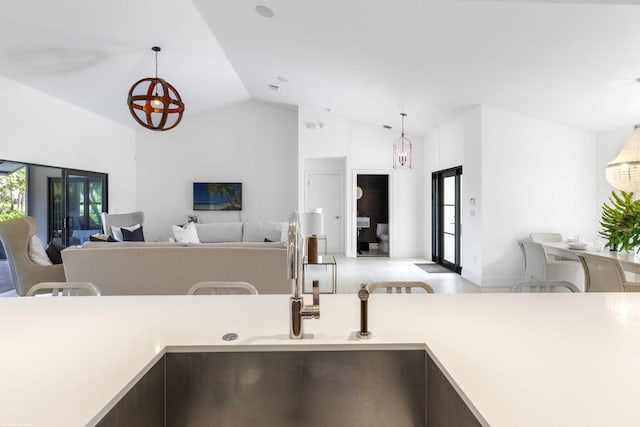 kitchen featuring lofted ceiling, a chandelier, light countertops, and open floor plan