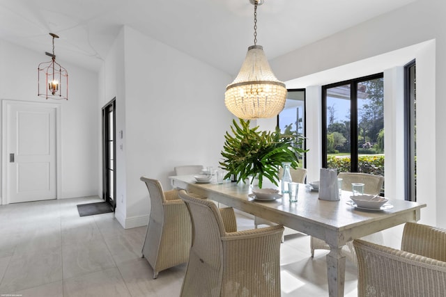 dining room with vaulted ceiling, baseboards, and an inviting chandelier