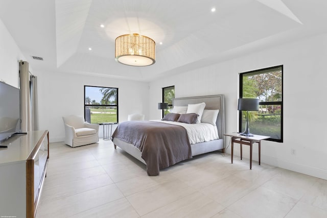 bedroom featuring a tray ceiling, visible vents, baseboards, and recessed lighting