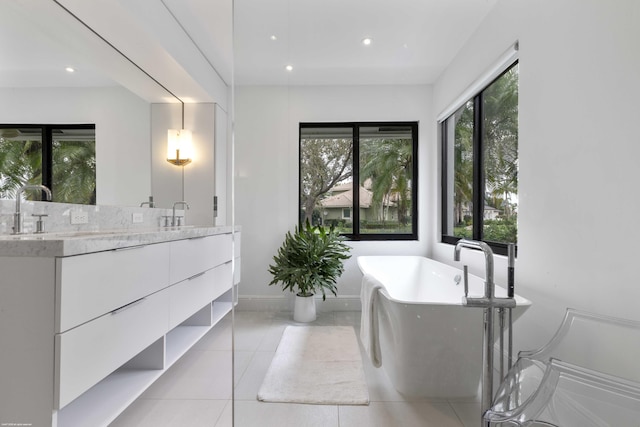 full bath with a freestanding tub, tile patterned flooring, recessed lighting, a sink, and double vanity