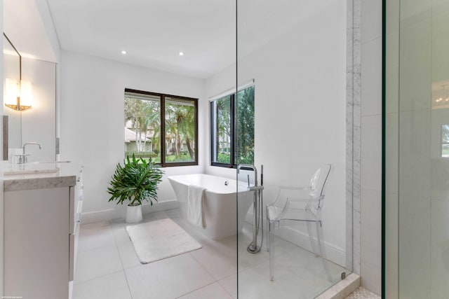 bathroom featuring tile patterned flooring, recessed lighting, vanity, baseboards, and a soaking tub