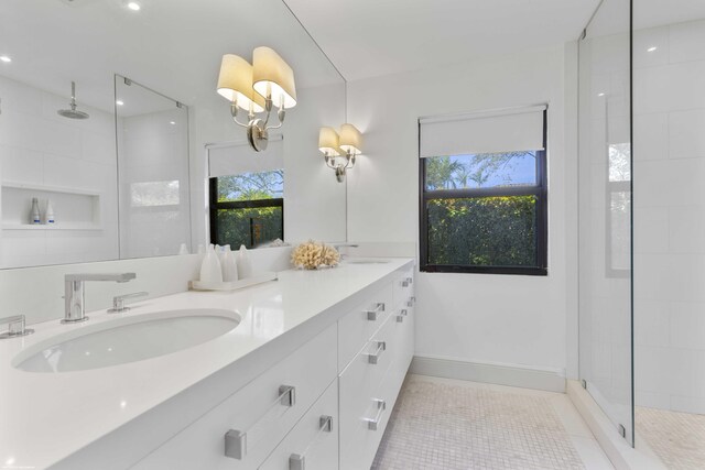 bathroom featuring a wealth of natural light, tile patterned flooring, a sink, and a shower stall