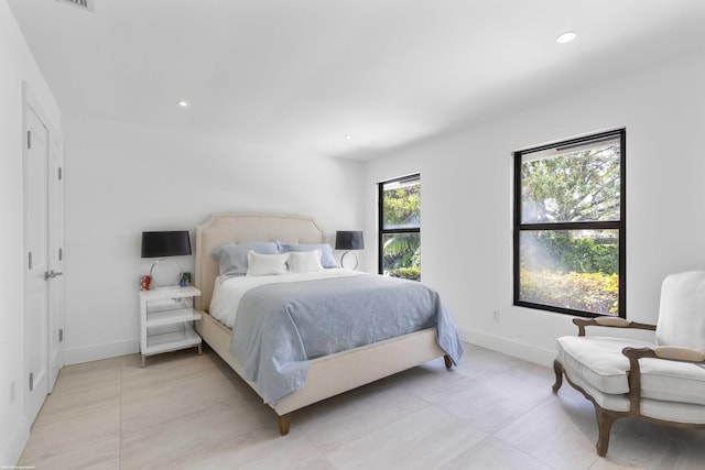 bedroom with light tile patterned floors, baseboards, and recessed lighting