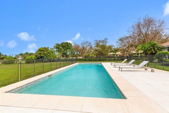 view of swimming pool featuring a patio area, a fenced in pool, fence, and a lawn