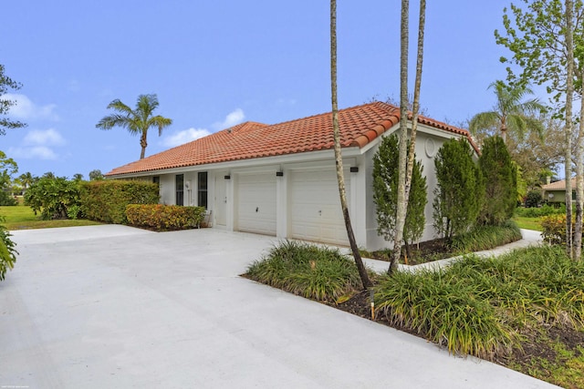 view of front of house with an attached garage, a tile roof, and stucco siding