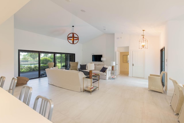 living room with high vaulted ceiling and a notable chandelier