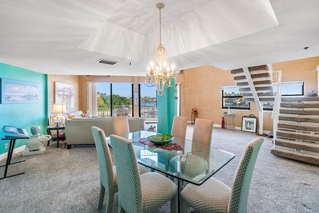 dining room with carpet and a notable chandelier