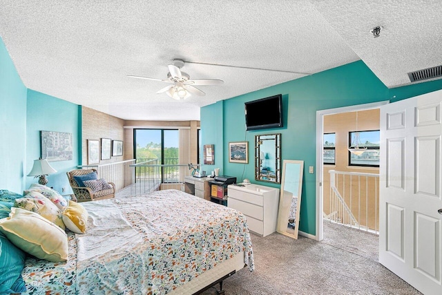 carpeted bedroom with ceiling fan and a textured ceiling