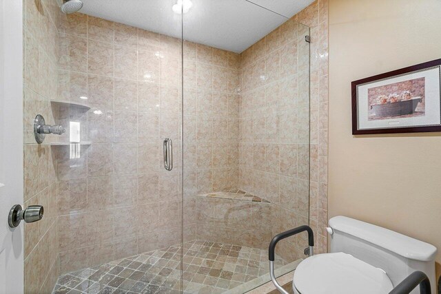 bathroom featuring toilet and an enclosed shower