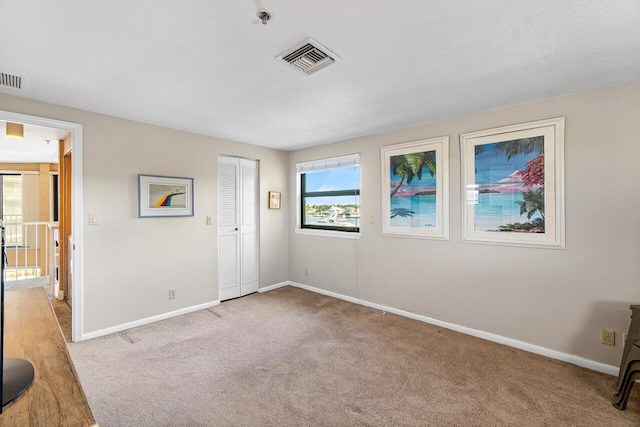 unfurnished bedroom featuring light carpet and a closet