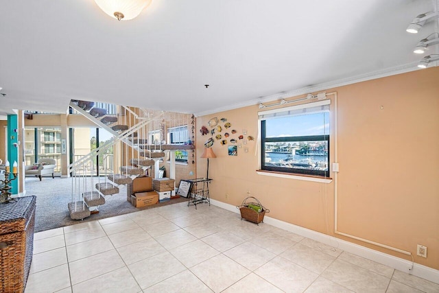 tiled living room featuring a healthy amount of sunlight and ornamental molding