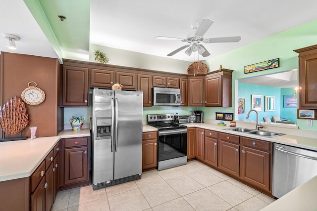 kitchen with ceiling fan, sink, light tile patterned floors, and stainless steel appliances