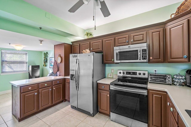 kitchen featuring kitchen peninsula, light tile patterned floors, stainless steel appliances, and ceiling fan