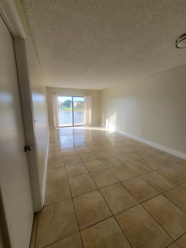 spare room with light tile patterned floors and a textured ceiling