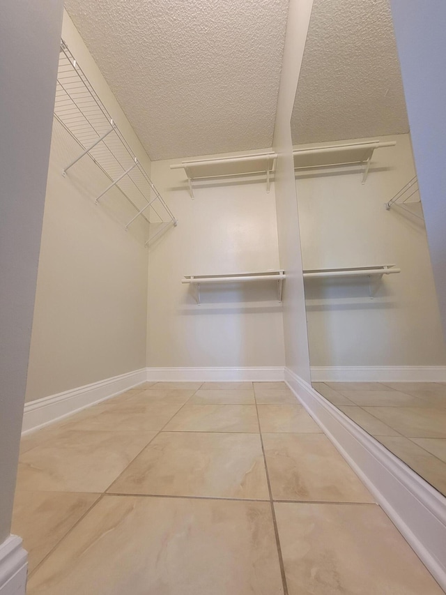 walk in closet with tile patterned flooring