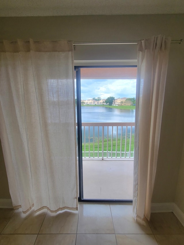 entryway with light tile patterned flooring and a water view