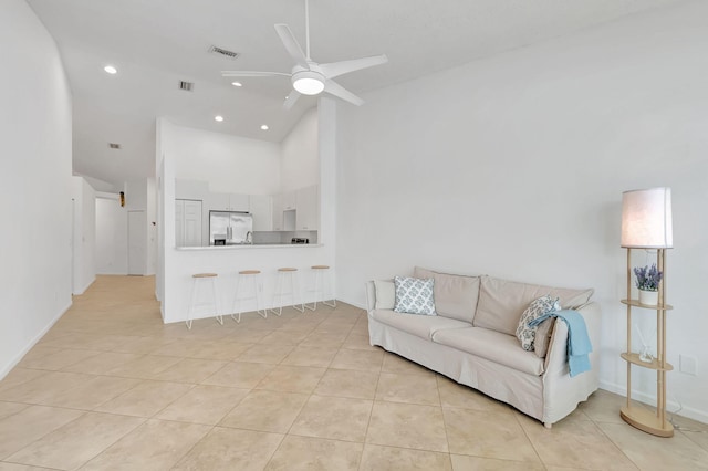 living room featuring ceiling fan, light tile patterned floors, and high vaulted ceiling