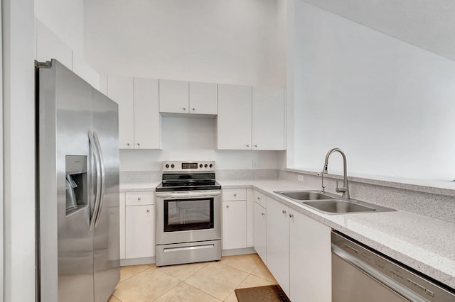 kitchen with sink, white cabinets, light tile patterned floors, and appliances with stainless steel finishes