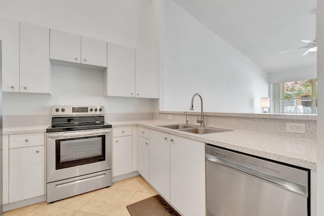 kitchen with white cabinets, sink, appliances with stainless steel finishes, and vaulted ceiling