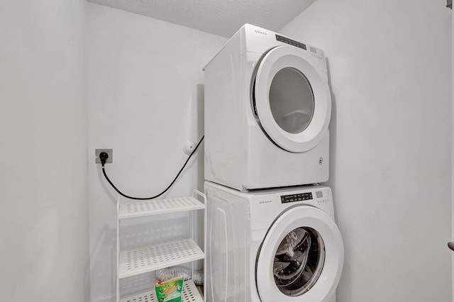 laundry area featuring a textured ceiling and stacked washer and clothes dryer