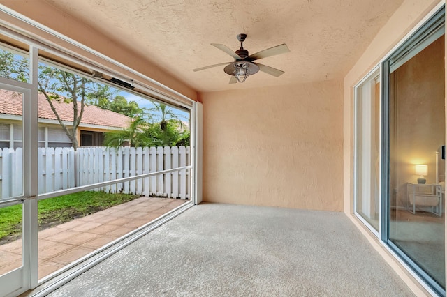 unfurnished sunroom featuring ceiling fan