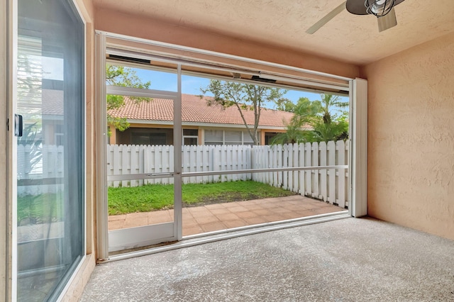 unfurnished sunroom featuring a wealth of natural light and ceiling fan