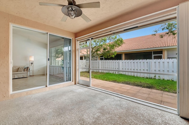 unfurnished sunroom with ceiling fan