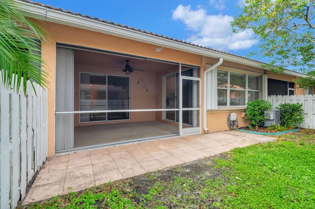 back of property featuring a patio area, a sunroom, and ceiling fan