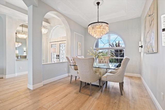 dining room featuring a chandelier, french doors, light hardwood / wood-style floors, and ornamental molding