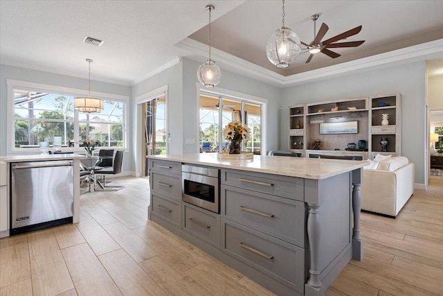 kitchen featuring appliances with stainless steel finishes, decorative light fixtures, and a wealth of natural light