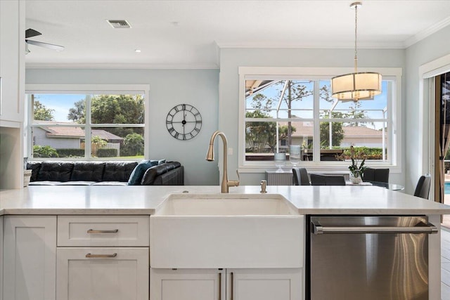 kitchen with stainless steel dishwasher, plenty of natural light, white cabinetry, and sink