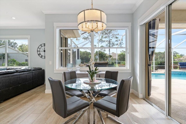 dining space featuring light hardwood / wood-style flooring, a chandelier, and ornamental molding