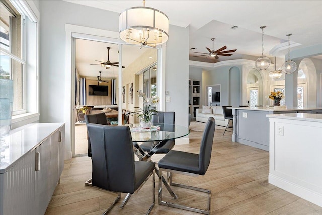 dining area with a chandelier, light hardwood / wood-style floors, and ornamental molding