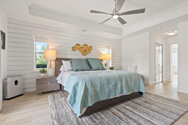 bedroom with wooden walls, light hardwood / wood-style floors, ceiling fan, and ornamental molding