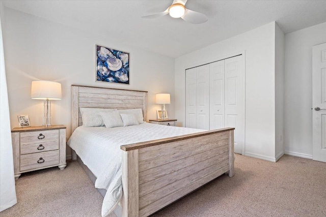 bedroom with ceiling fan, a closet, and light carpet