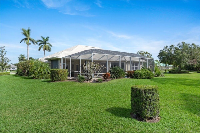 back of property with a lanai and a lawn