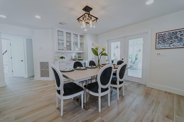 dining room featuring a chandelier, french doors, and light hardwood / wood-style floors